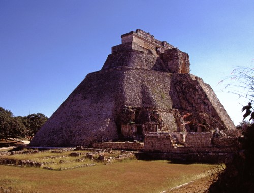 Mexiko Uxmal - Eine ovalförmige, sehr hohe Pyramide. Im Vordergrund Rasen und weitere Ausgrabungsflächen