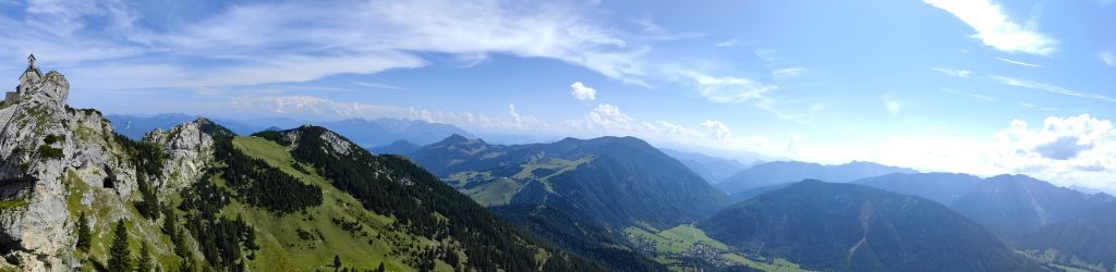 Wendelstein - Panoramablick vom Wendelstein mit grünen Hügeln, Bergen und einem klaren blauen Himmel.
